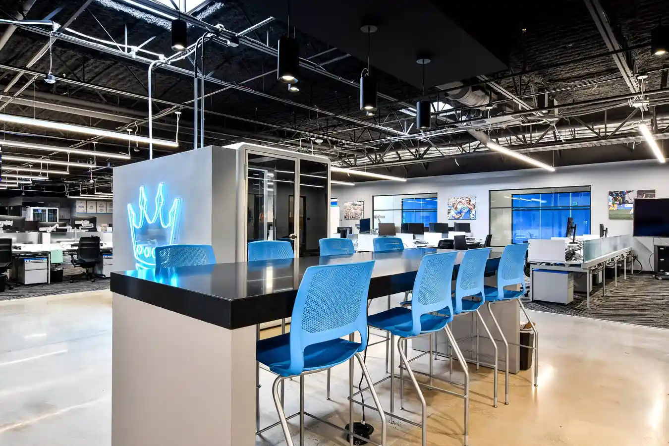 Open floor plan office space with desks, tables, and meeting pods