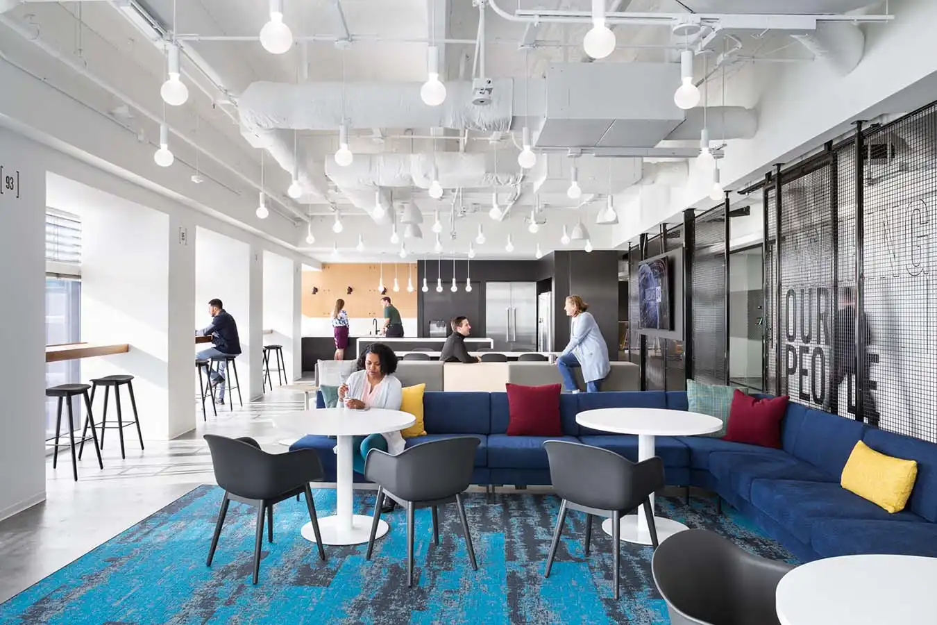 Employees eating and talking in a workplace kitchen and lounge