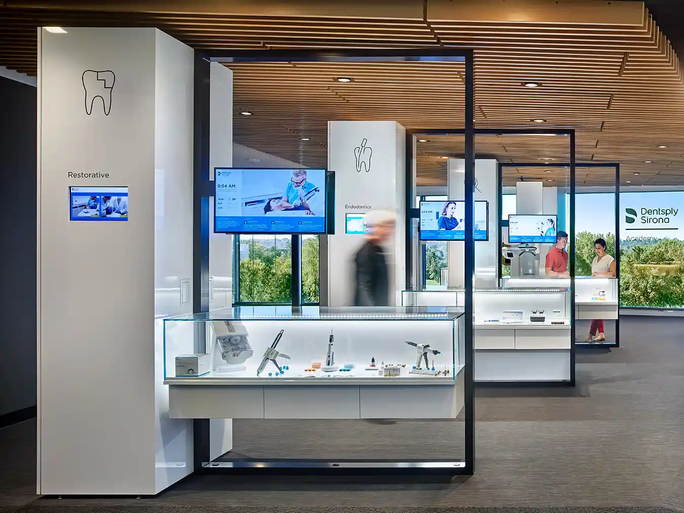 Denstply Sirona booths with TVs and medical equipment