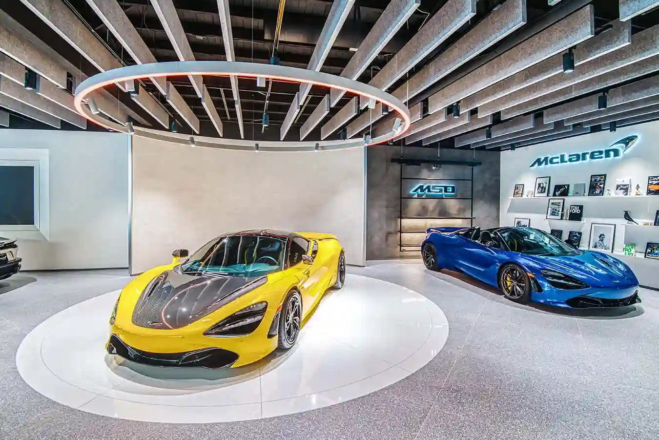 McClaren dealership with vehicles and shelved photos
