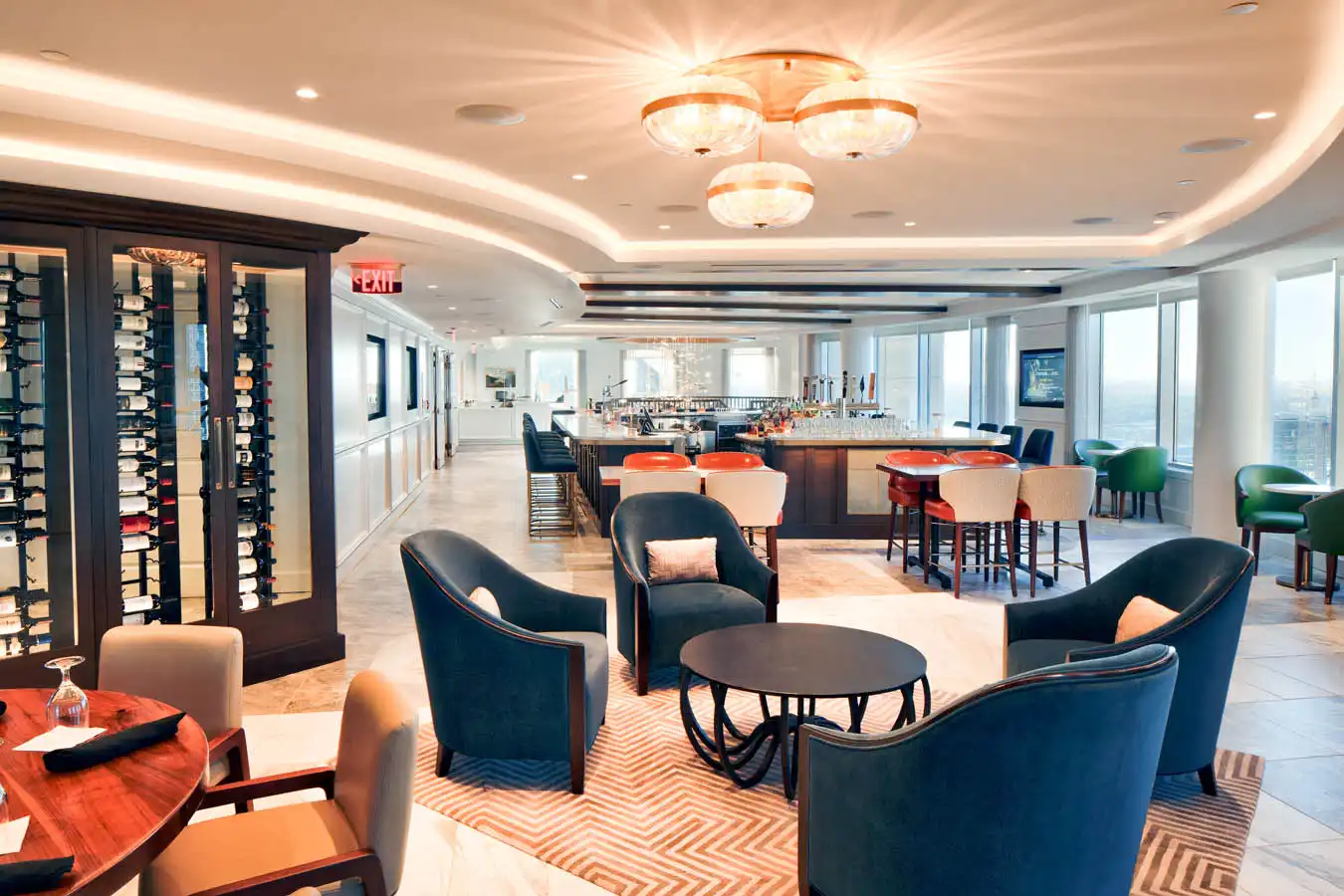 Charlotte City Club lounge with circular table seating, and square bar, and office in the back